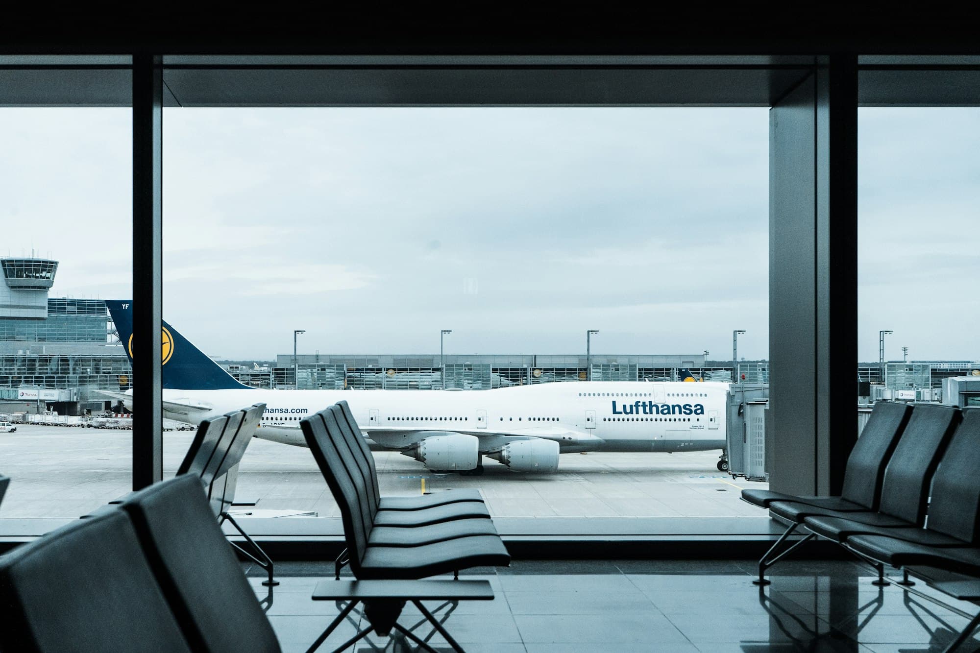 Empty departure gate seating overlooking a parked wide-body aircraft