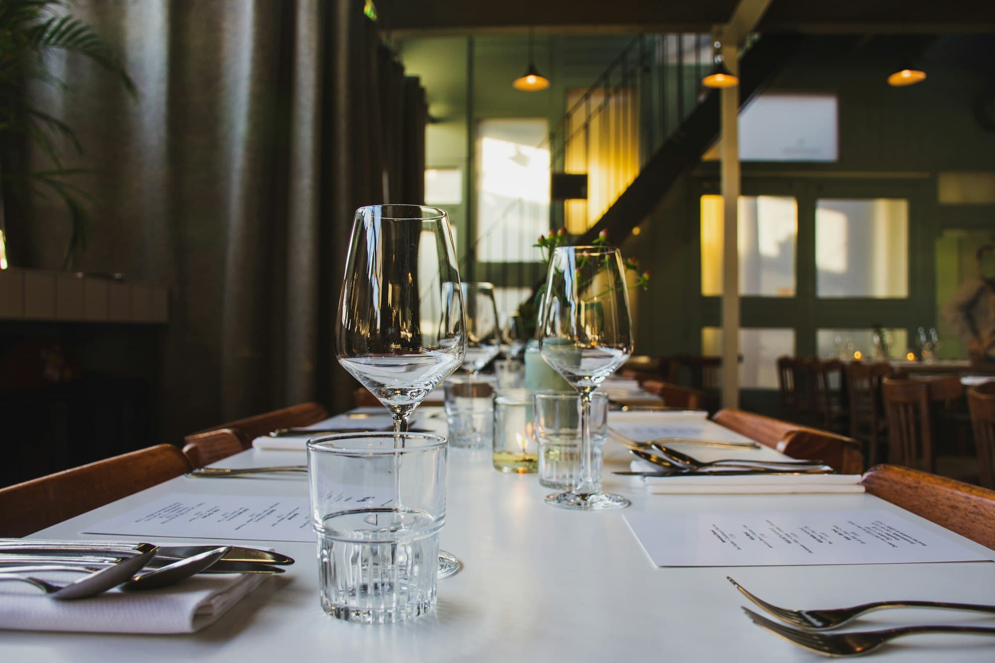 Restaurant table set with wine glasses and cutlery before a client dinner